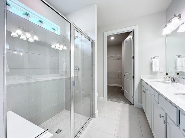 bathroom featuring tile patterned floors, a shower with door, and vanity