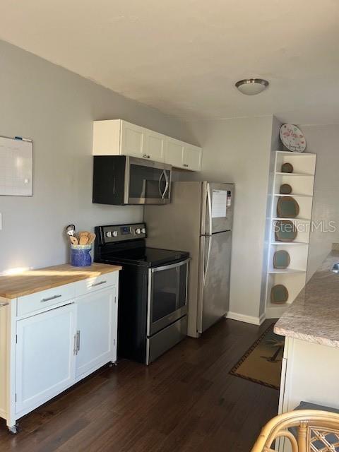 kitchen with dark hardwood / wood-style floors, white cabinetry, and stainless steel appliances