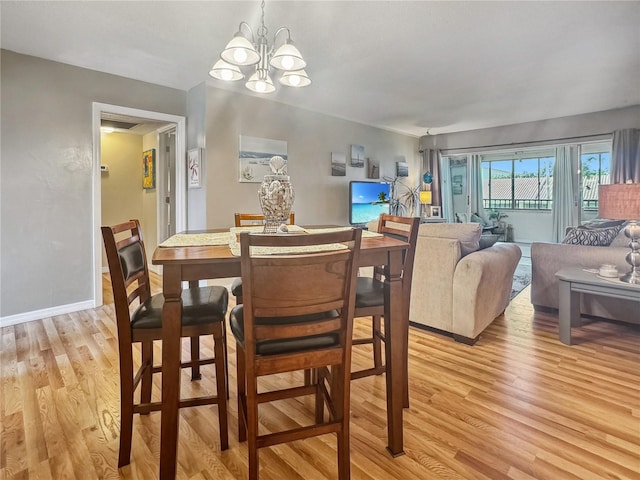 dining space with a notable chandelier and light hardwood / wood-style floors