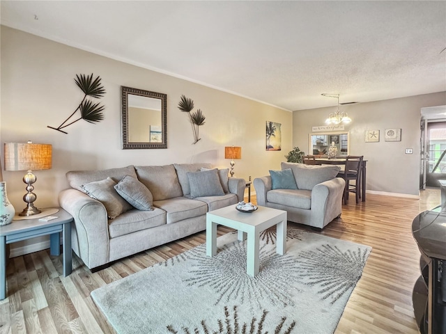 living room with a textured ceiling, light hardwood / wood-style flooring, and a notable chandelier