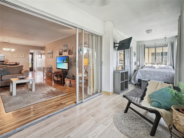 bedroom with a notable chandelier and light wood-type flooring