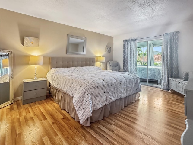 bedroom featuring light hardwood / wood-style floors and a textured ceiling