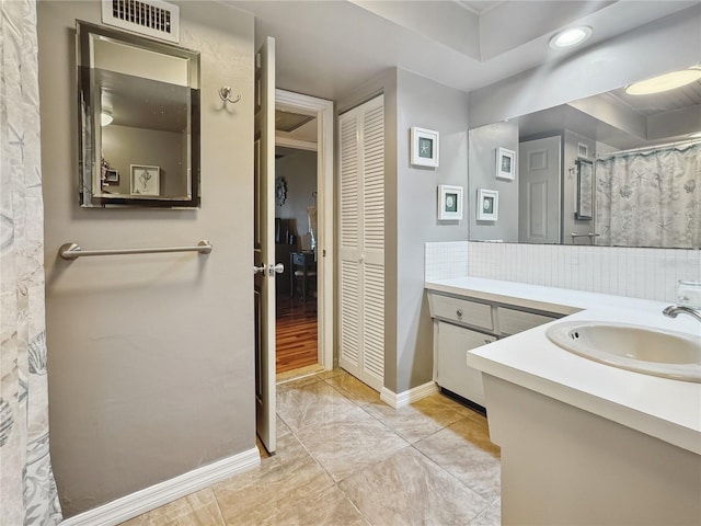 bathroom with vanity and decorative backsplash