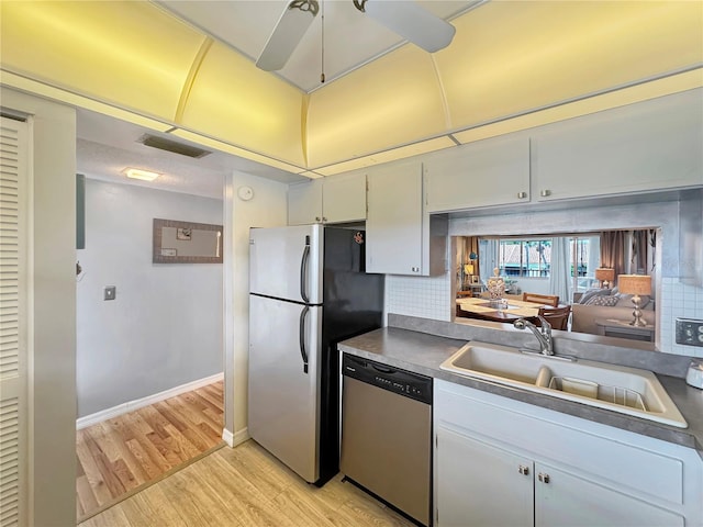 kitchen featuring white cabinets, sink, light hardwood / wood-style flooring, tasteful backsplash, and stainless steel appliances