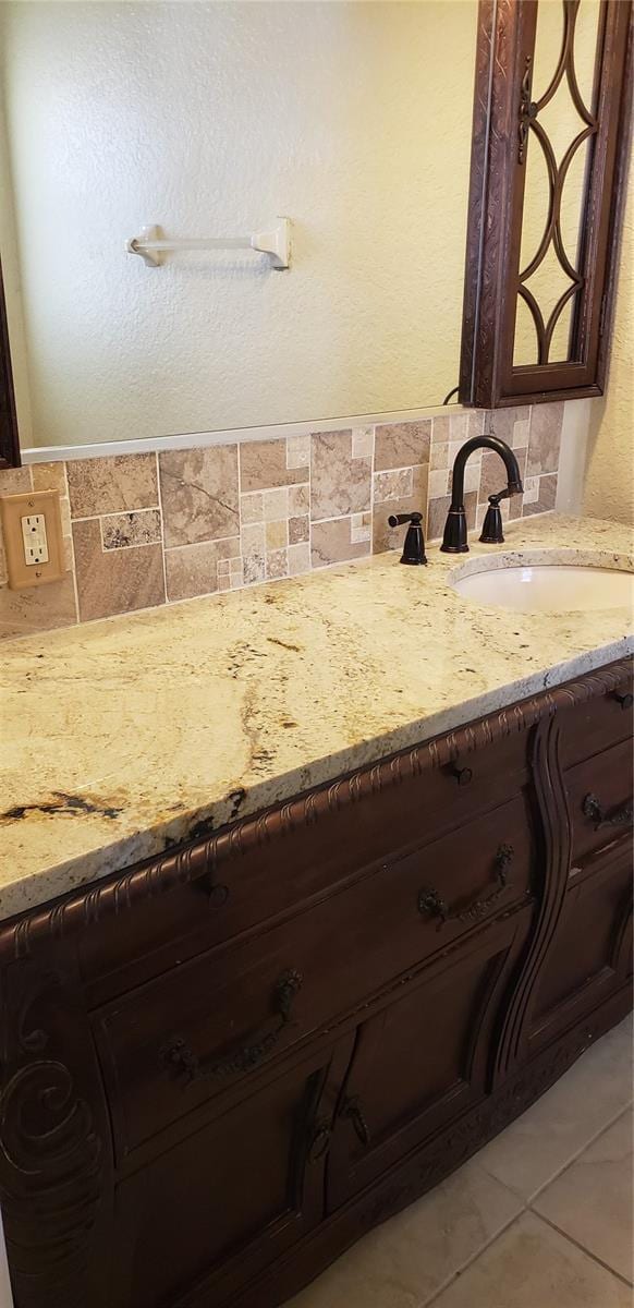 bathroom with tile patterned flooring, vanity, and tasteful backsplash