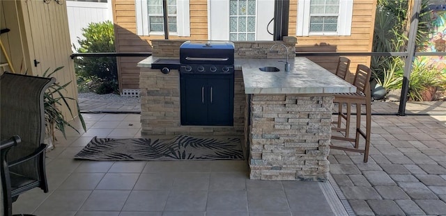 view of patio with exterior kitchen, area for grilling, and a wet bar