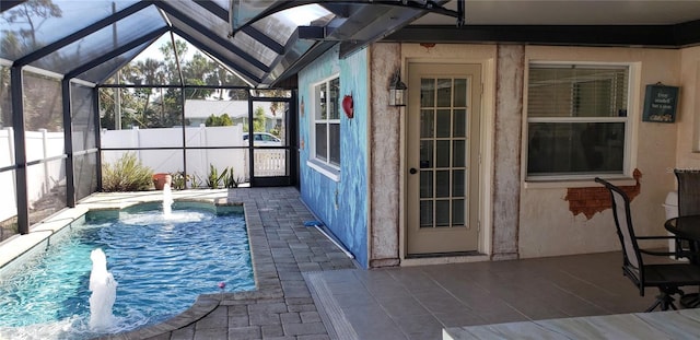 view of swimming pool with pool water feature, a patio, and glass enclosure