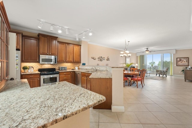 kitchen featuring stainless steel appliances, decorative backsplash, hanging light fixtures, kitchen peninsula, and light tile patterned flooring