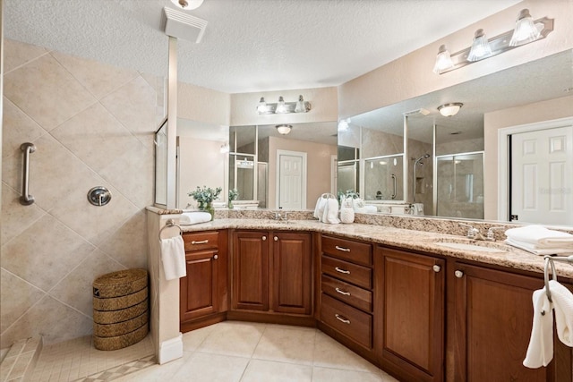 bathroom featuring vanity, tile patterned flooring, a textured ceiling, and an enclosed shower