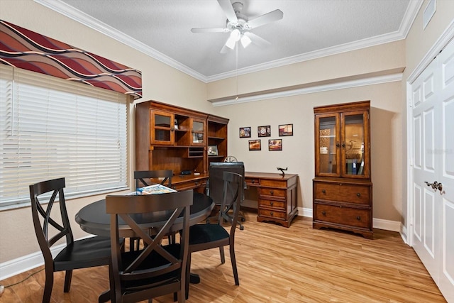 dining room with ceiling fan, a textured ceiling, ornamental molding, and light wood-type flooring