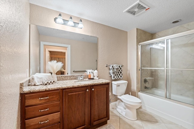 full bathroom featuring toilet, tile patterned flooring, a textured ceiling, vanity, and shower / bath combination with glass door