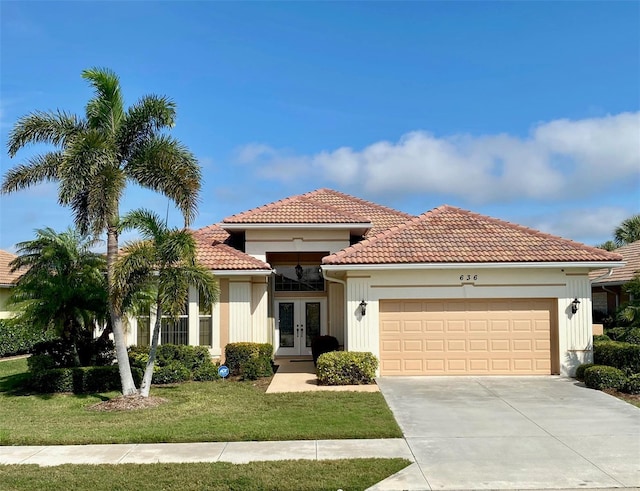 mediterranean / spanish-style home featuring a front yard, french doors, and a garage