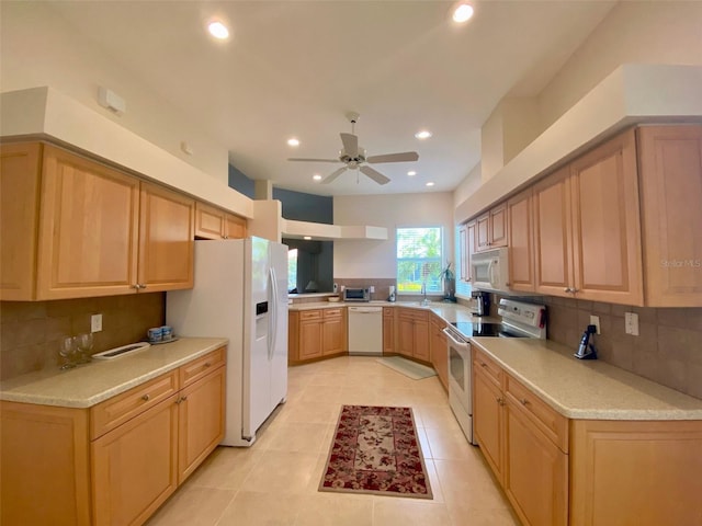 kitchen featuring white appliances, decorative backsplash, ceiling fan, and light brown cabinetry