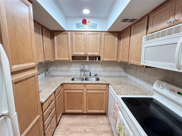 kitchen with light wood-type flooring, white appliances, backsplash, and sink