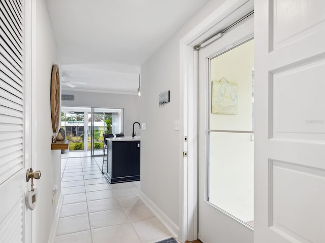 corridor featuring light tile patterned floors and sink