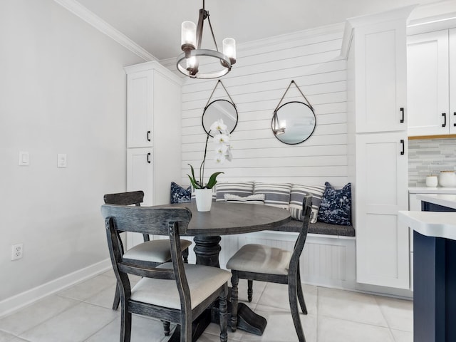 tiled dining room featuring breakfast area, a notable chandelier, and ornamental molding