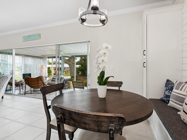 tiled dining area featuring a chandelier and ornamental molding