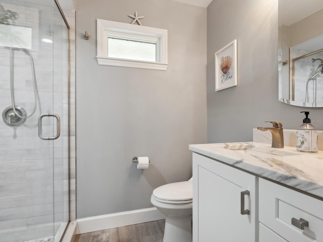 bathroom with hardwood / wood-style flooring, vanity, toilet, and a shower with door