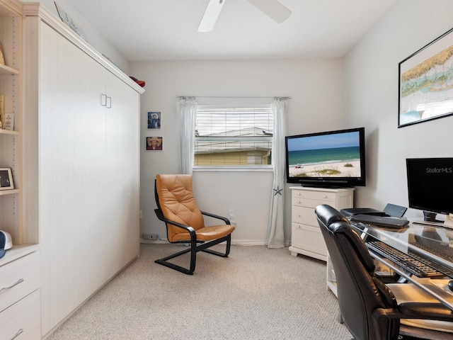 carpeted home office featuring ceiling fan