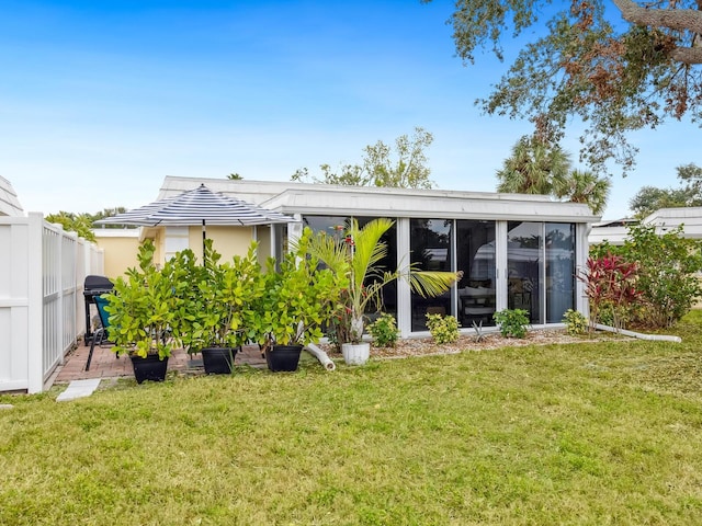 back of house featuring a sunroom and a yard