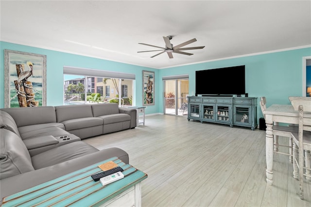 living room featuring light hardwood / wood-style floors, ceiling fan, and crown molding