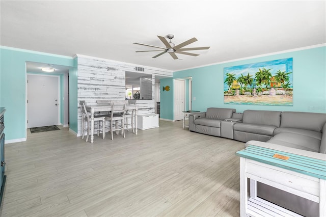 living room with ornamental molding, ceiling fan, and light hardwood / wood-style flooring