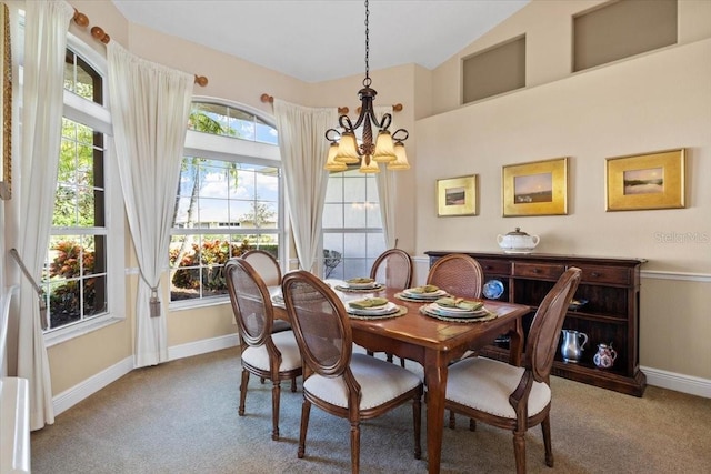 dining room featuring carpet, vaulted ceiling, and a chandelier