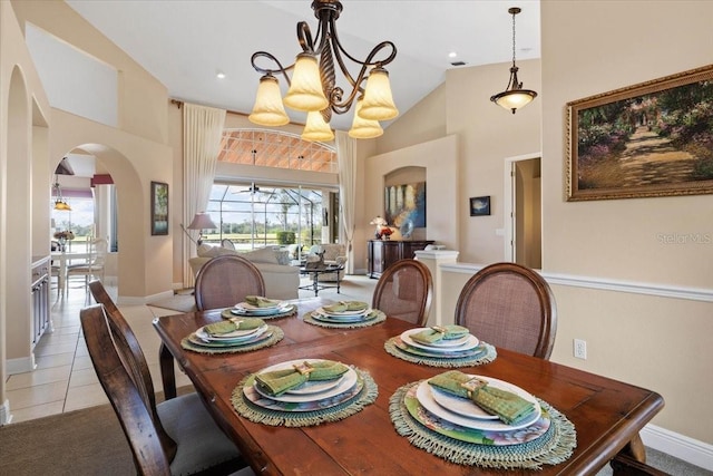 dining space with plenty of natural light, light tile patterned floors, a chandelier, and lofted ceiling