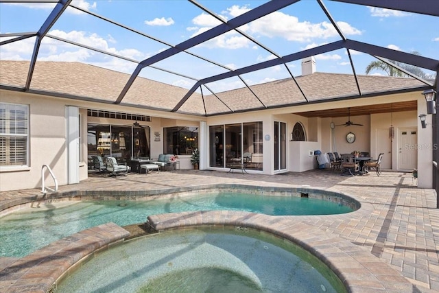 view of pool with an in ground hot tub, glass enclosure, ceiling fan, and a patio area