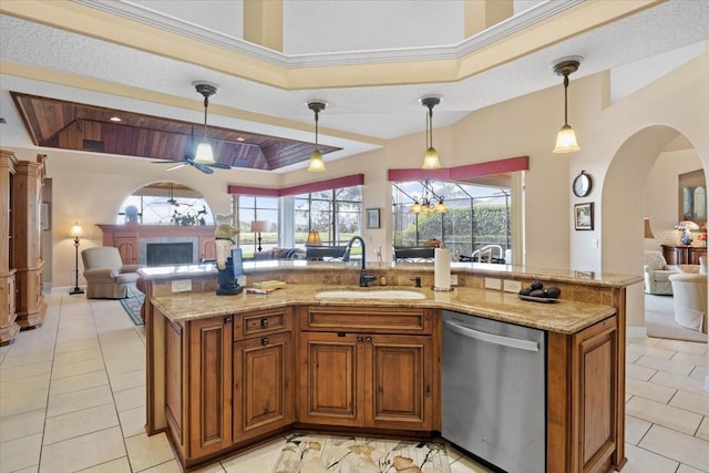 kitchen with a kitchen island with sink, dishwasher, decorative light fixtures, and sink