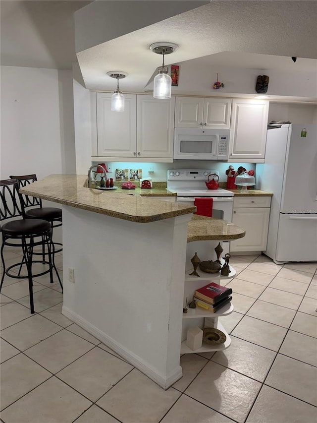 kitchen featuring white cabinetry, kitchen peninsula, hanging light fixtures, and white appliances