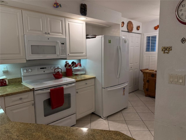 kitchen featuring light tile patterned flooring, white cabinetry, light stone counters, and white appliances