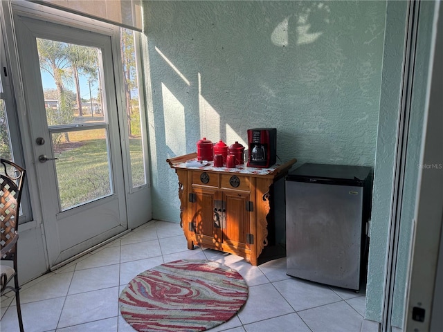 doorway to outside with light tile patterned floors