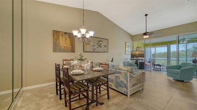 dining area with vaulted ceiling, ceiling fan with notable chandelier, and light tile patterned floors