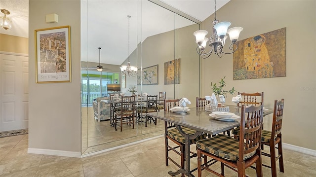 tiled dining space with ceiling fan with notable chandelier and high vaulted ceiling