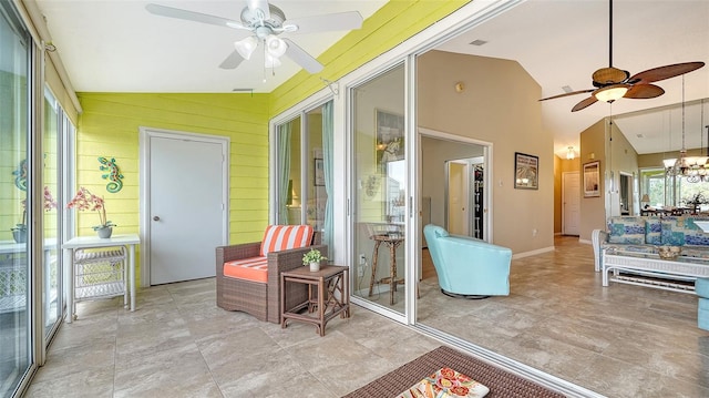 sunroom featuring lofted ceiling and ceiling fan with notable chandelier