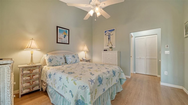 bedroom with light wood-type flooring, ceiling fan, and a closet