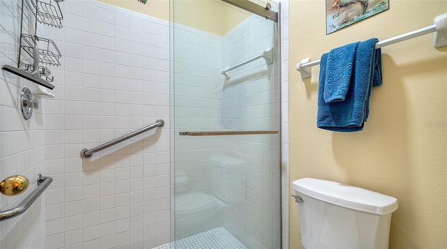 bathroom with a shower with shower door and toilet