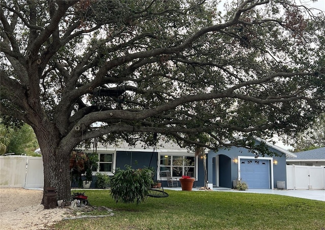 view of front of home with a garage and a front lawn