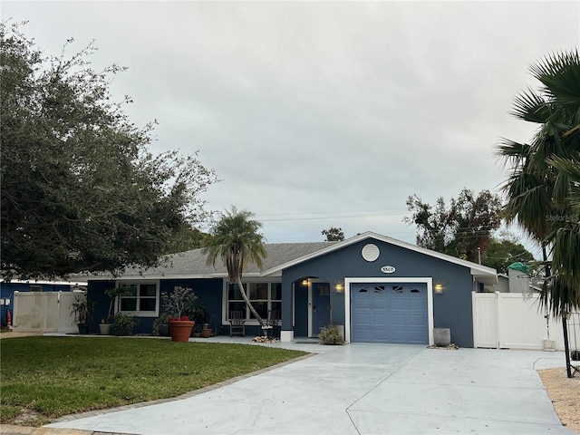 single story home featuring a garage and a front lawn