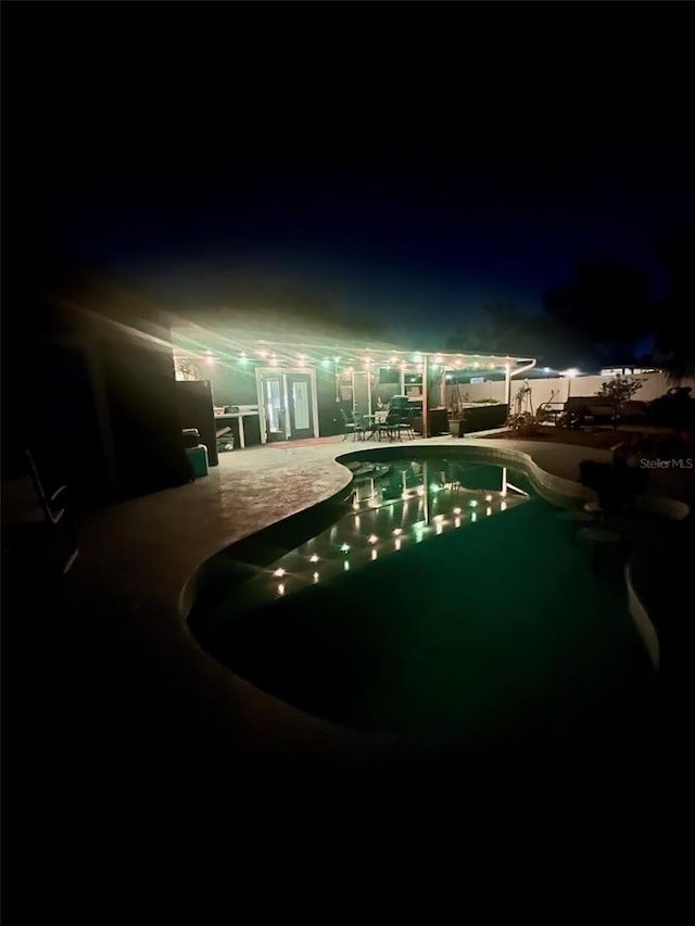 pool at twilight featuring a patio area