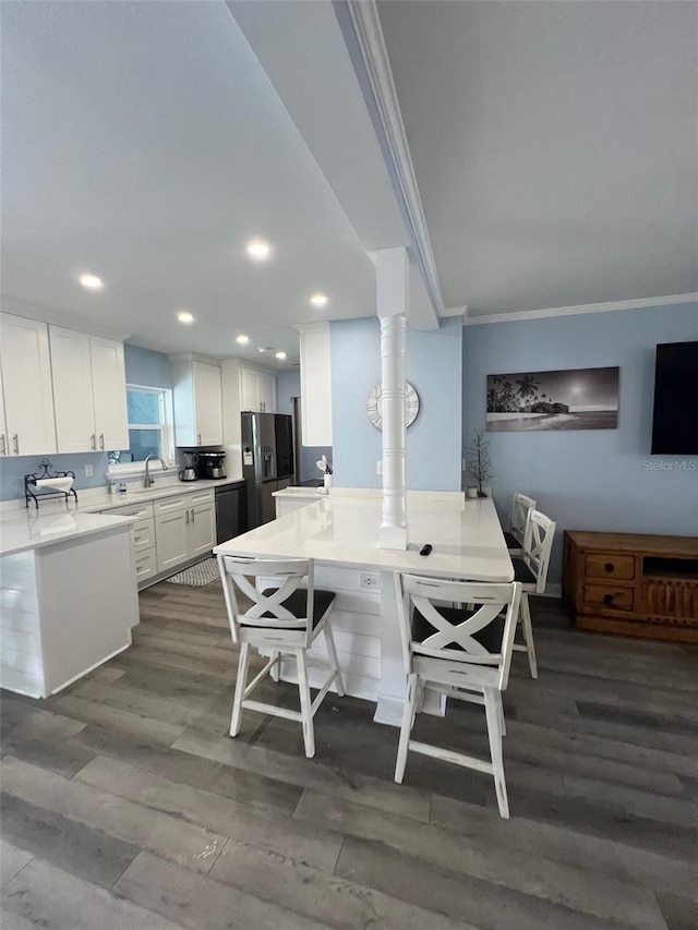 dining space with dark hardwood / wood-style flooring, sink, and ornamental molding