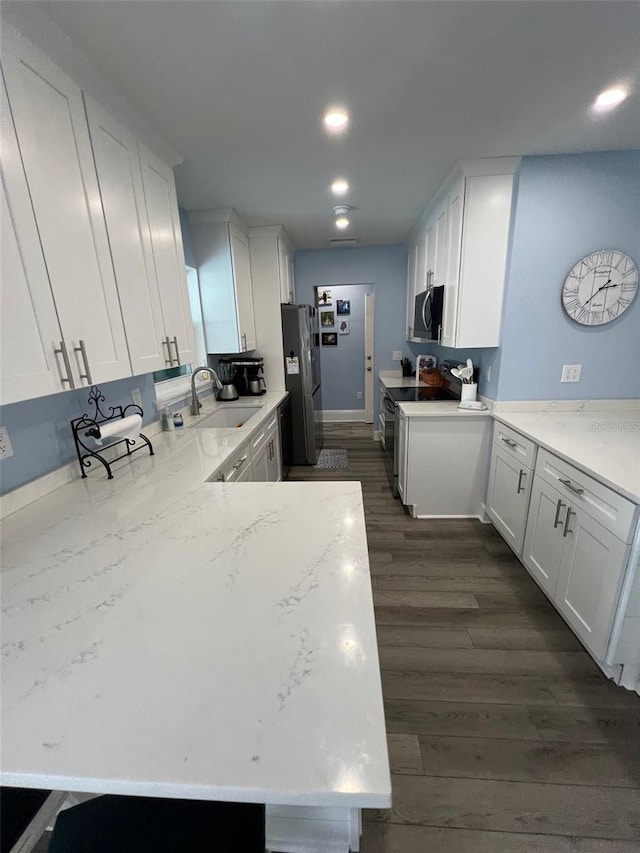 kitchen featuring white cabinetry, sink, dark wood-type flooring, light stone counters, and appliances with stainless steel finishes