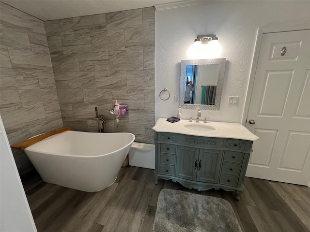 bathroom featuring hardwood / wood-style floors, vanity, a bathtub, and crown molding