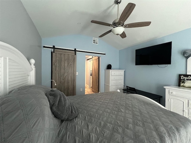 bedroom featuring ceiling fan, a barn door, and lofted ceiling