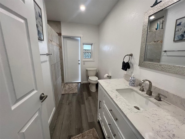 bathroom with vanity, toilet, and wood-type flooring