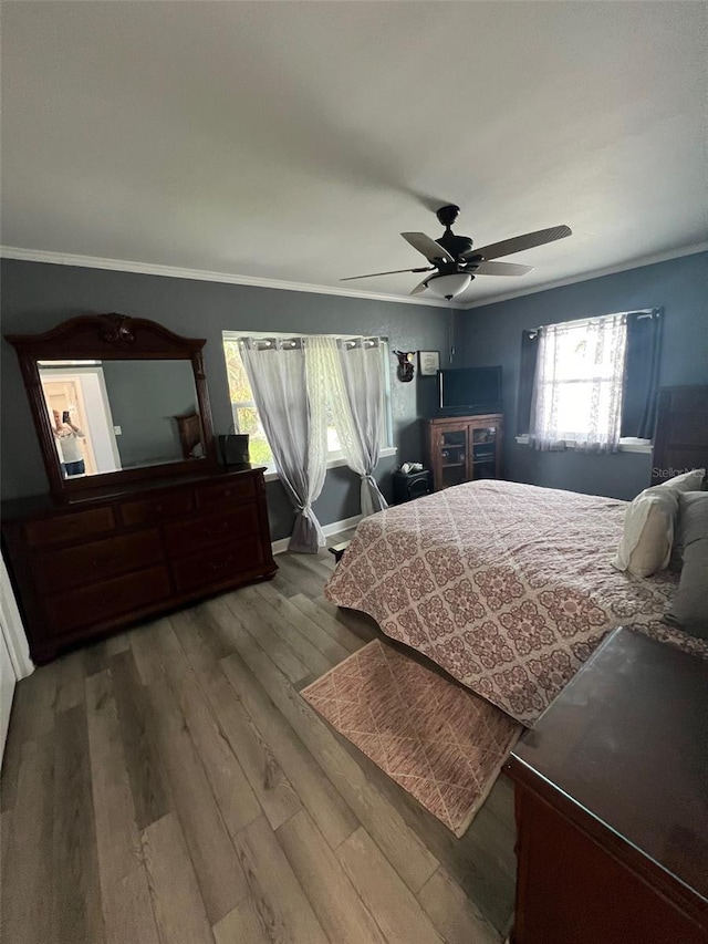 bedroom featuring hardwood / wood-style flooring, ceiling fan, and crown molding