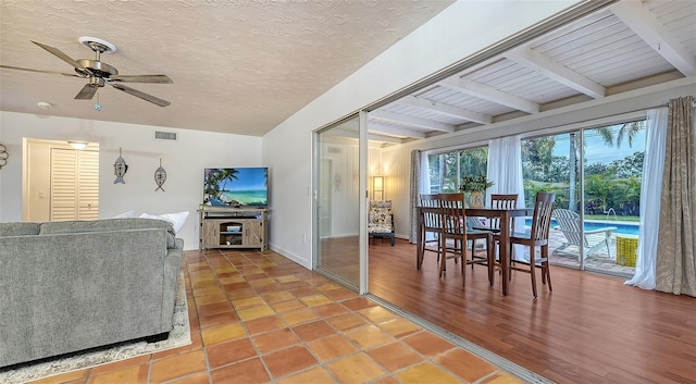 interior space with visible vents, ceiling fan, a textured ceiling, beamed ceiling, and baseboards