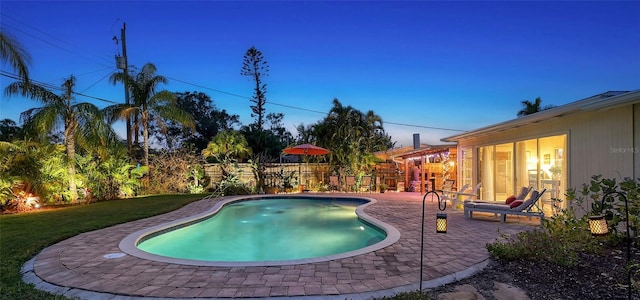 view of pool featuring a patio area, a fenced in pool, fence, and a lawn