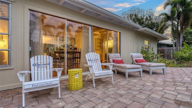 patio terrace at dusk featuring fence